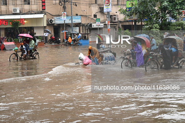 Vehicles and rickshaws drive with passengers through the waterlogged streets of Dhaka, Bangladesh, on October 5, 2024, after heavy rainfalls...