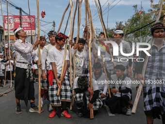 Balinese men carry long wooden sticks and take part in the Mekotek ritual in Munggu Village, Bali, Indonesia, on October 5, 2024. Mekotek is...