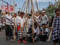 Balinese men carry long wooden sticks and take part in the Mekotek ritual in Munggu Village, Bali, Indonesia, on October 5, 2024. Mekotek is...