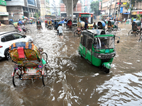 Vehicles and rickshaws drive with passengers through the waterlogged streets of Dhaka, Bangladesh, on October 5, 2024, after heavy rainfalls...