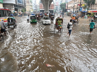 Vehicles and rickshaws drive with passengers through the waterlogged streets of Dhaka, Bangladesh, on October 5, 2024, after heavy rainfalls...