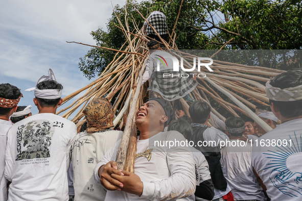 Balinese men climb pyramid-like structures using long wooden sticks during the Mekotek ritual in Munggu Village, Bali, Indonesia, on October...