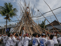 A Balinese man climbs pyramid-like structures using long wooden sticks during the Mekotek ritual in Munggu Village, Bali, Indonesia, on Octo...