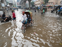 Vehicles and rickshaws drive with passengers through the waterlogged streets of Dhaka, Bangladesh, on October 5, 2024, after heavy rainfalls...