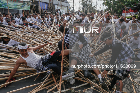 Balinese men fall from pyramid-like structures using long wooden sticks during the Mekotek ritual in Munggu Village, Bali, Indonesia, on Oct...