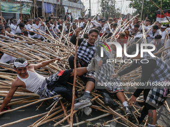 Balinese men fall from pyramid-like structures using long wooden sticks during the Mekotek ritual in Munggu Village, Bali, Indonesia, on Oct...