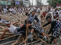 Balinese men fall from pyramid-like structures using long wooden sticks during the Mekotek ritual in Munggu Village, Bali, Indonesia, on Oct...