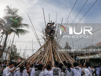 Balinese men climb pyramid-like structures using long wooden sticks during the Mekotek ritual in Munggu Village, Bali, Indonesia, on October...