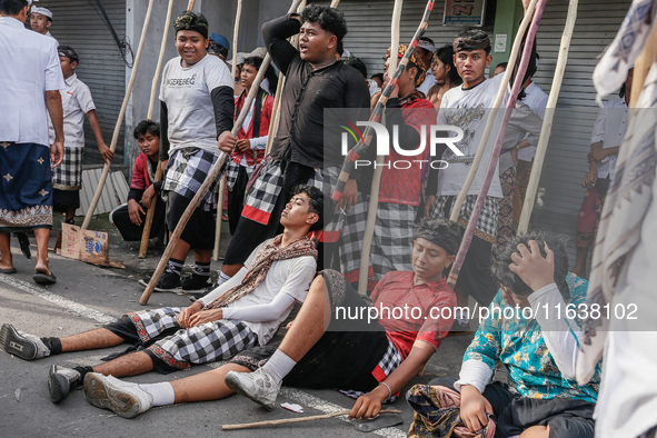 Balinese men carry long wooden sticks and take part in the Mekotek ritual in Munggu Village, Bali, Indonesia, on October 5, 2024. Mekotek is...