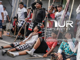 Balinese men carry long wooden sticks and take part in the Mekotek ritual in Munggu Village, Bali, Indonesia, on October 5, 2024. Mekotek is...