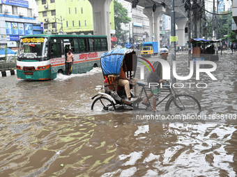 Vehicles and rickshaws drive with passengers through the waterlogged streets of Dhaka, Bangladesh, on October 5, 2024, after heavy rainfalls...