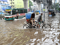 Vehicles and rickshaws drive with passengers through the waterlogged streets of Dhaka, Bangladesh, on October 5, 2024, after heavy rainfalls...