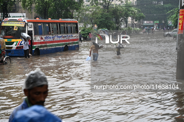 Vehicles and rickshaws drive with passengers through the waterlogged streets of Dhaka, Bangladesh, on October 5, 2024, after heavy rainfalls...