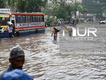 Vehicles and rickshaws drive with passengers through the waterlogged streets of Dhaka, Bangladesh, on October 5, 2024, after heavy rainfalls...