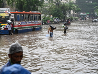 Vehicles and rickshaws drive with passengers through the waterlogged streets of Dhaka, Bangladesh, on October 5, 2024, after heavy rainfalls...