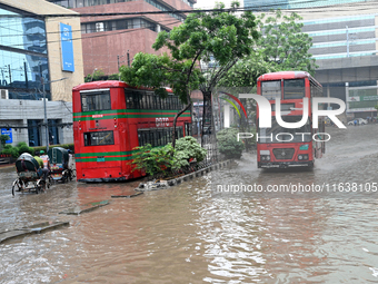 Vehicles and rickshaws drive with passengers through the waterlogged streets of Dhaka, Bangladesh, on October 5, 2024, after heavy rainfalls...