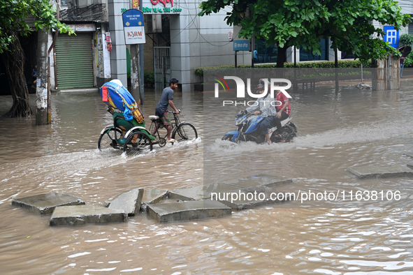 Vehicles and rickshaws drive with passengers through the waterlogged streets of Dhaka, Bangladesh, on October 5, 2024, after heavy rainfalls...