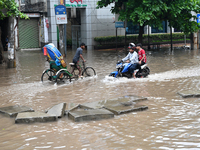 Vehicles and rickshaws drive with passengers through the waterlogged streets of Dhaka, Bangladesh, on October 5, 2024, after heavy rainfalls...