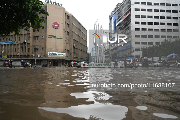 Vehicles and rickshaws drive with passengers through the waterlogged streets of Dhaka, Bangladesh, on October 5, 2024, after heavy rainfalls...