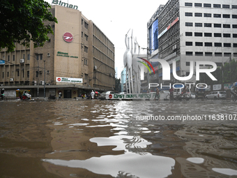 Vehicles and rickshaws drive with passengers through the waterlogged streets of Dhaka, Bangladesh, on October 5, 2024, after heavy rainfalls...