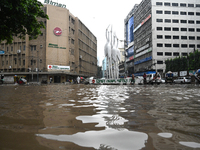 Vehicles and rickshaws drive with passengers through the waterlogged streets of Dhaka, Bangladesh, on October 5, 2024, after heavy rainfalls...