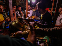 Kashmiri men eat barbecues and other non-vegetarian items from a vendor in Sopore, Jammu and Kashmir, India, on October 5, 2024. (