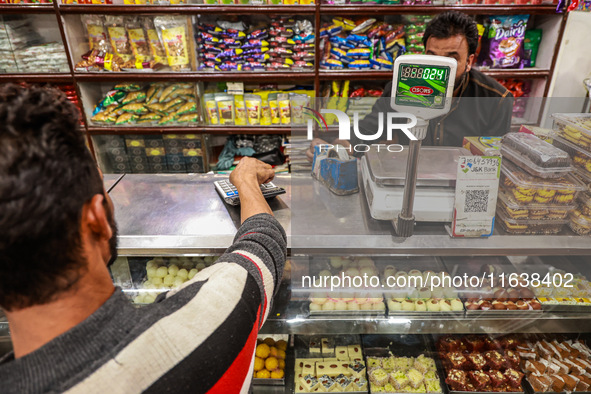 A person purchases sweets from a shop in Sopore, Jammu and Kashmir, India, on October 5, 2024. 