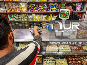 A person purchases sweets from a shop in Sopore, Jammu and Kashmir, India, on October 5, 2024. (