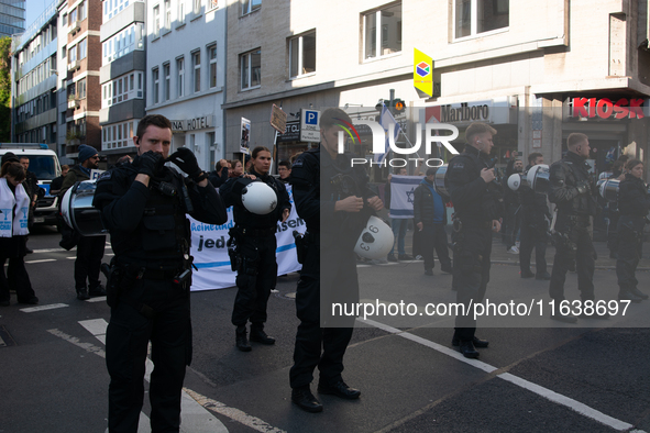 Police block the protesters from pro-Israeli protesters as a thousand protesters take part in a protest demanding a ceasefire and opposing o...