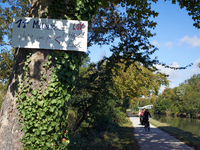 Cyclists ride on the Canal du Midi banks, and a placard reads 'EUR14 bn for the LGV rather than for education or hospitals'. Zadists, or dev...