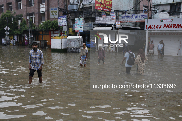 Residents walk through a waterlogged street after heavy rainfall in Dhaka, Bangladesh, on October 5, 2024. The flash flood hits several area...