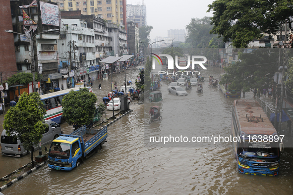 Residents make their way through a waterlogged street after heavy rainfall in Dhaka, Bangladesh, on October 5, 2024. The flash flood hits se...