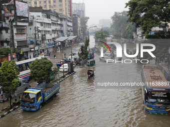 Residents make their way through a waterlogged street after heavy rainfall in Dhaka, Bangladesh, on October 5, 2024. The flash flood hits se...