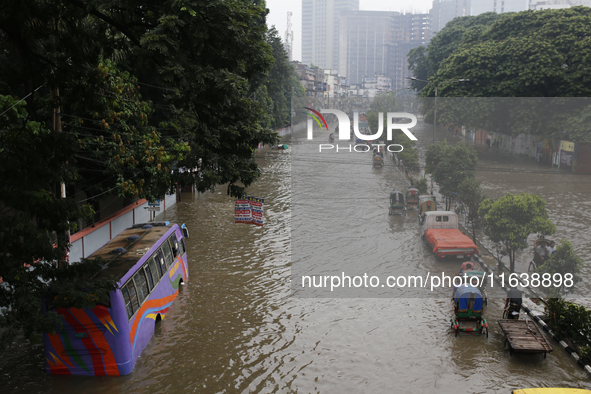 Residents make their way through a waterlogged street after heavy rainfall in Dhaka, Bangladesh, on October 5, 2024. The flash flood hits se...