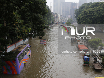 Residents make their way through a waterlogged street after heavy rainfall in Dhaka, Bangladesh, on October 5, 2024. The flash flood hits se...