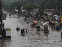 Residents make their way through a waterlogged street after heavy rainfall in Dhaka, Bangladesh, on October 5, 2024. The flash flood hits se...