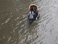 A man pulls his rickshaw through a waterlogged street during rainfall in Dhaka, Bangladesh, on September 26, 2024. The flash flood hits seve...