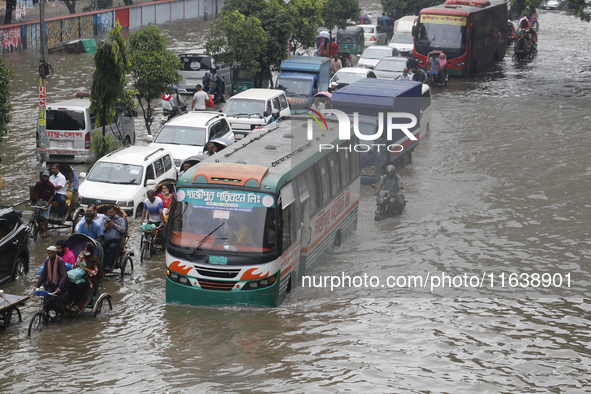 Residents make their way through a waterlogged street after heavy rainfall in Dhaka, Bangladesh, on October 5, 2024. The flash flood hits se...