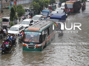 Residents make their way through a waterlogged street after heavy rainfall in Dhaka, Bangladesh, on October 5, 2024. The flash flood hits se...