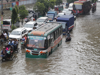 Residents make their way through a waterlogged street after heavy rainfall in Dhaka, Bangladesh, on October 5, 2024. The flash flood hits se...