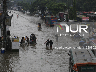 Residents make their way through a waterlogged street after heavy rainfall in Dhaka, Bangladesh, on October 5, 2024. The flash flood hits se...