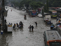 Residents make their way through a waterlogged street after heavy rainfall in Dhaka, Bangladesh, on October 5, 2024. The flash flood hits se...