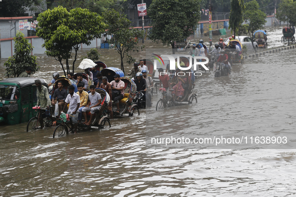 Residents make their way through a waterlogged street after heavy rainfall in Dhaka, Bangladesh, on October 5, 2024. The flash flood hits se...