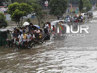 Residents make their way through a waterlogged street after heavy rainfall in Dhaka, Bangladesh, on October 5, 2024. The flash flood hits se...