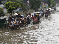 Residents make their way through a waterlogged street after heavy rainfall in Dhaka, Bangladesh, on October 5, 2024. The flash flood hits se...