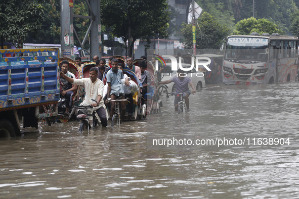 Residents make their way through a waterlogged street after heavy rainfall in Dhaka, Bangladesh, on October 5, 2024. The flash flood hits se...