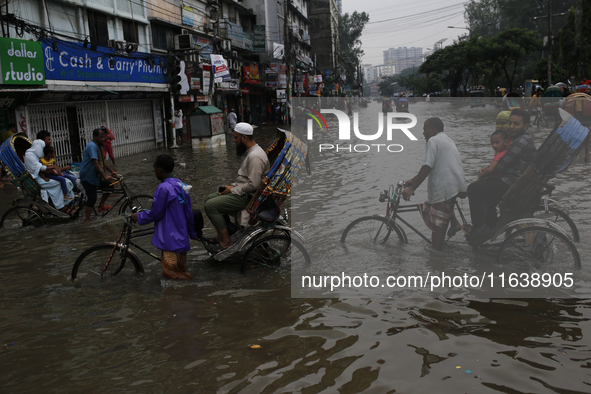 Rickshaw pullers make their way through a waterlogged street during rainfall in Dhaka, Bangladesh, on September 26, 2024. The flash flood hi...