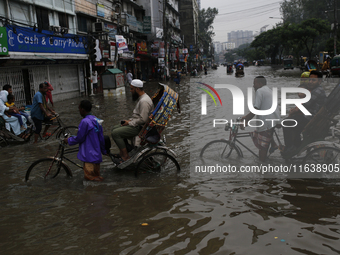 Rickshaw pullers make their way through a waterlogged street during rainfall in Dhaka, Bangladesh, on September 26, 2024. The flash flood hi...