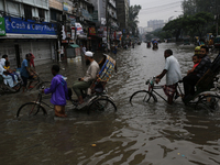 Rickshaw pullers make their way through a waterlogged street during rainfall in Dhaka, Bangladesh, on September 26, 2024. The flash flood hi...