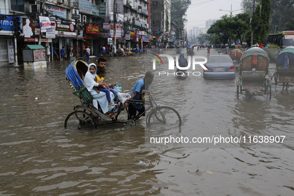 Rickshaw pullers make their way through a waterlogged street during rainfall in Dhaka, Bangladesh, on September 26, 2024. The flash flood hi...